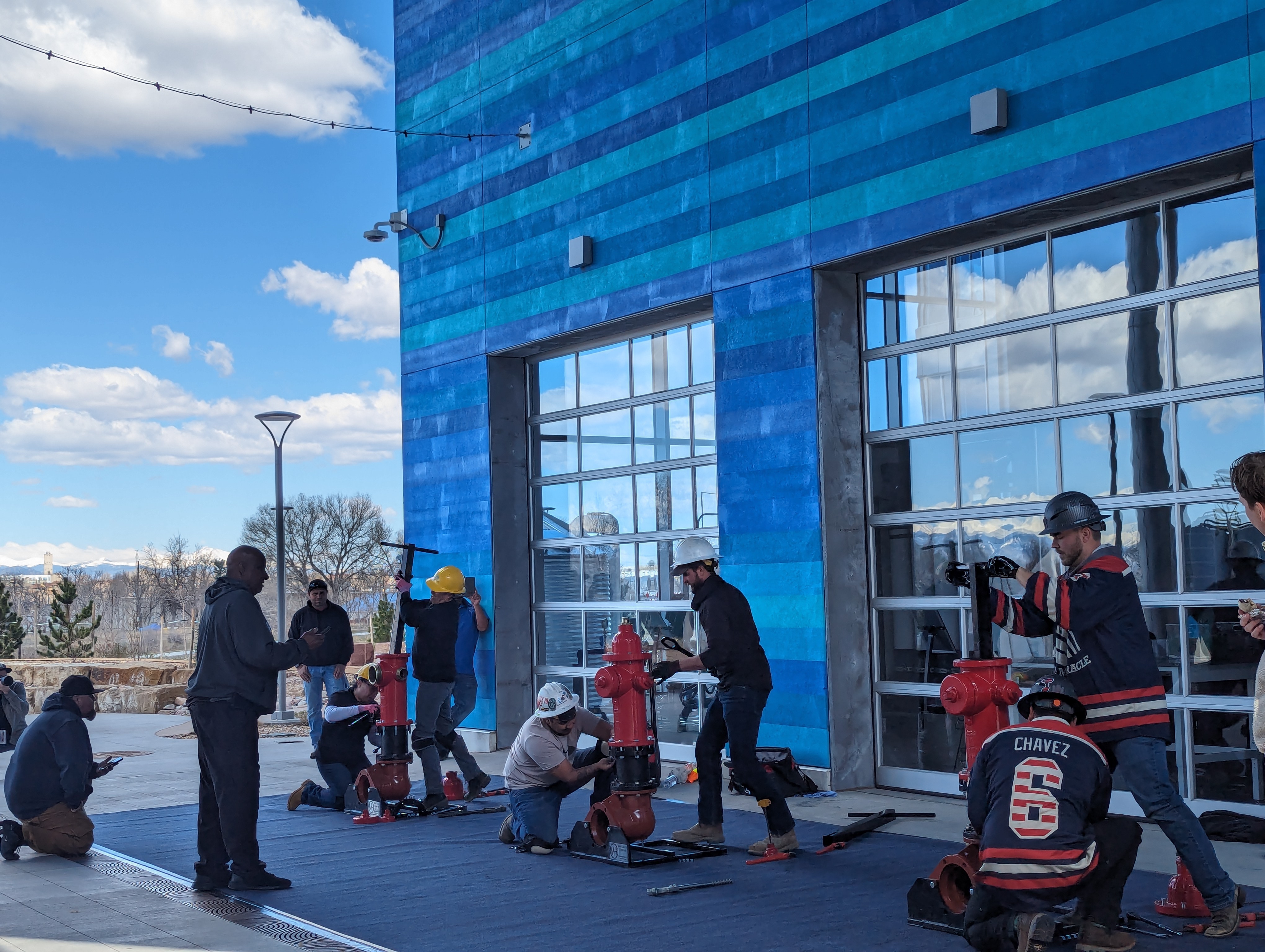 small teams of people put fire hydrants together outside during an activity