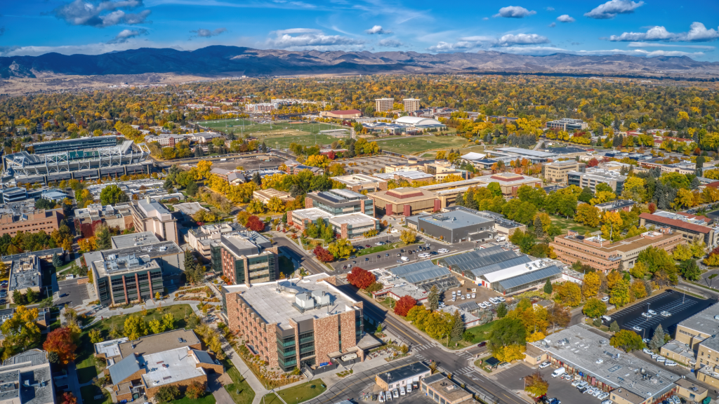 An aerial view of Fort Collins, Colorado and Colorado State campus with mountains in the background on a sunny fall day