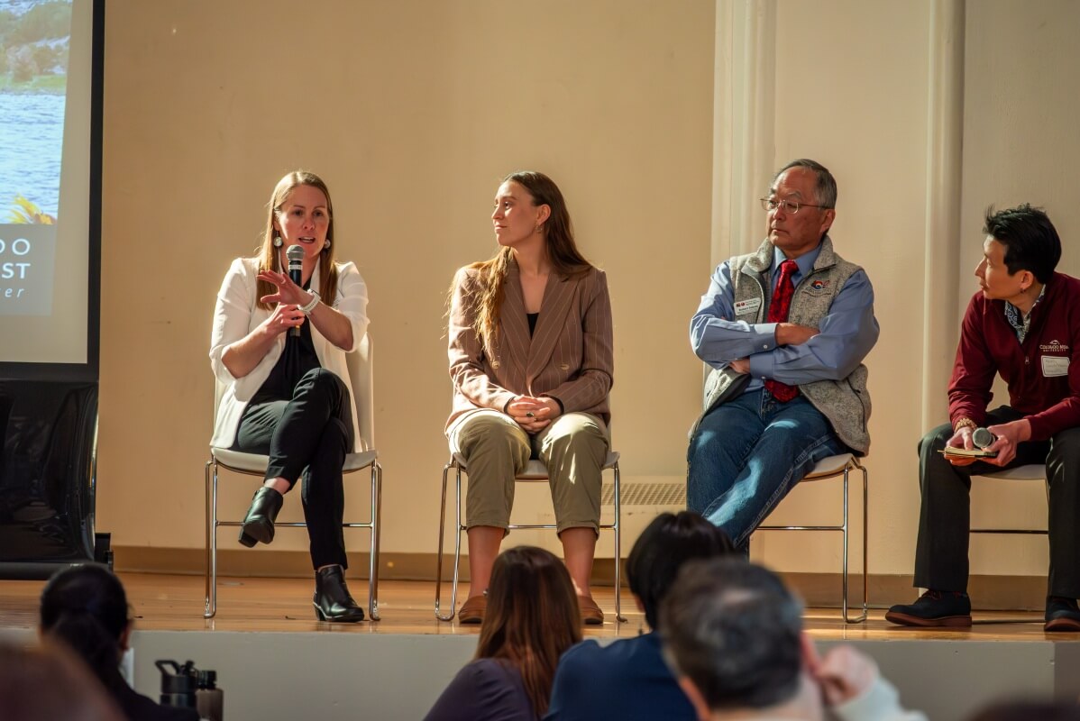 Three panelists and a moderator from the “Shared Water, Shared Voices: Effective Stakeholder Engagement” panel, sitting in chairs on stage, with one person speaking into a microphone.