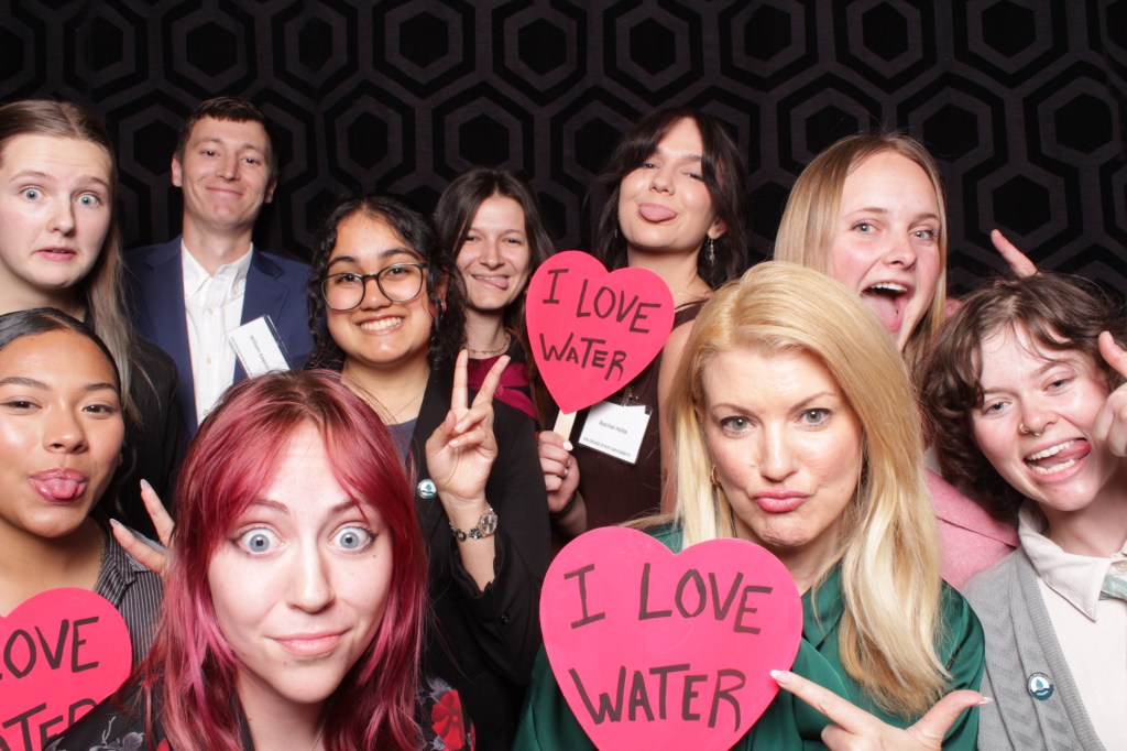 Group of people poses with props in photo booth
