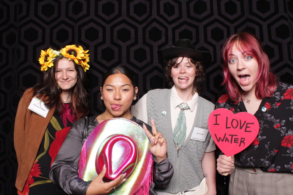 Group of people poses with props in photo booth