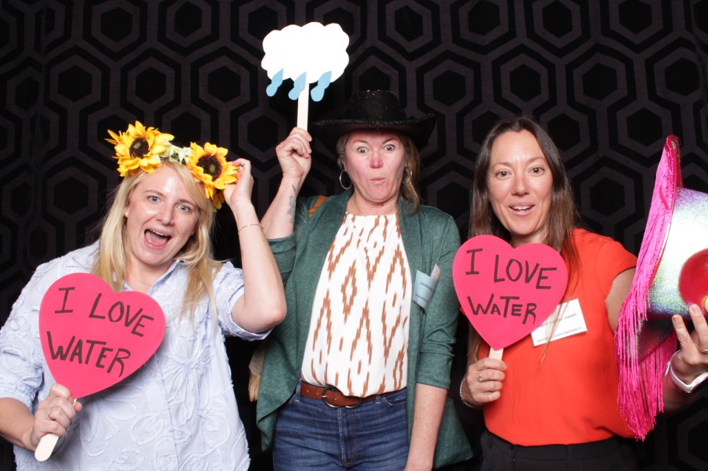 People pose with props in photo booth