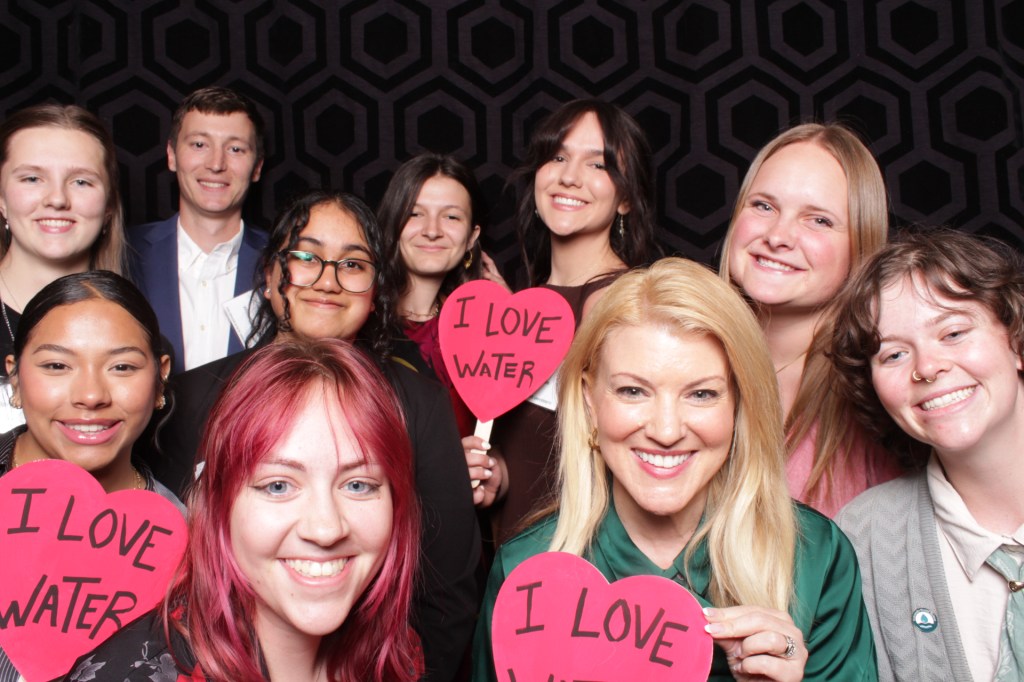 Group of people poses with props in photo booth