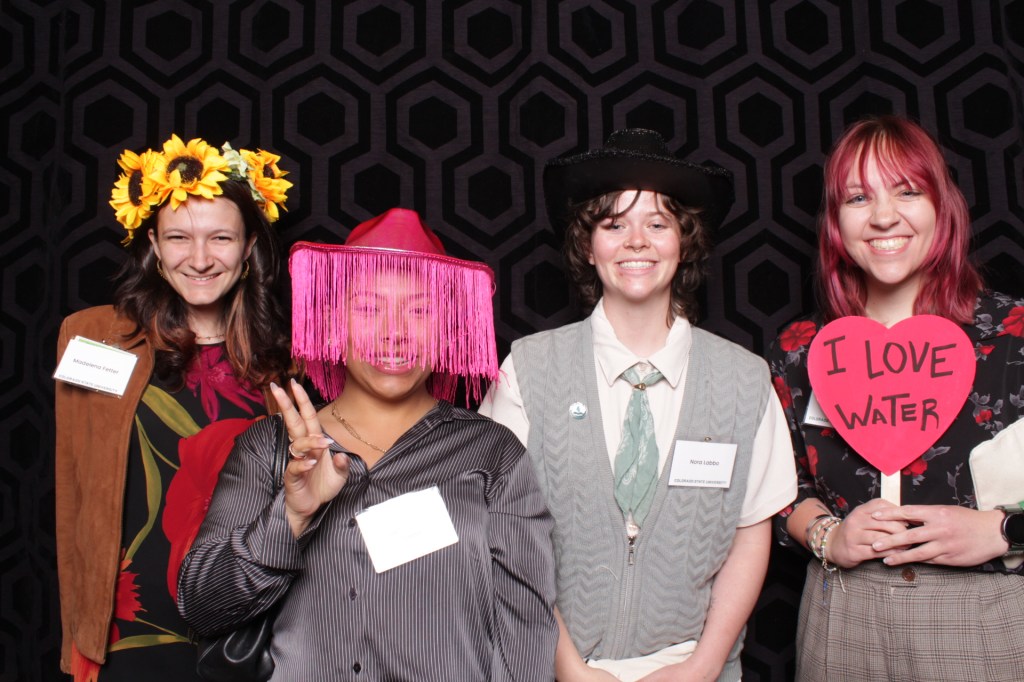 Group of people poses with props in photo booth